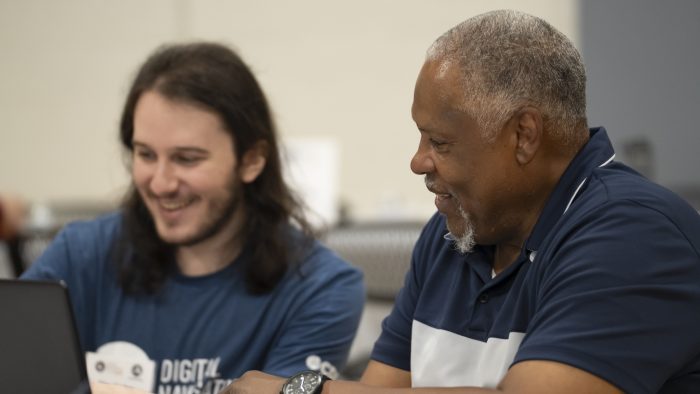 photo of AmeriCorps Digital Navigator helping a community member